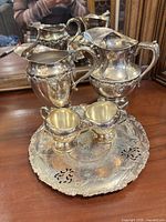 Front view of entire five-piece silver-plated set on wood surface