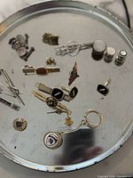 Overview of entire lot on tray showing tie bars, cufflinks, studs, pins