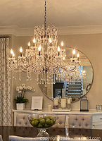 Chandelier illuminated in dining room showing crystal prisms and multi-arm design
