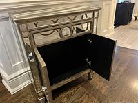 Cabinet front angled with left door open showing black interior and shelf