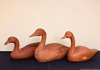 Front view of all three wooden goose decoys showing sizes and finishes