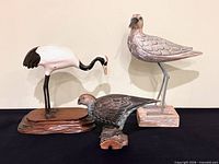 Group shot of three bird figurines on stands