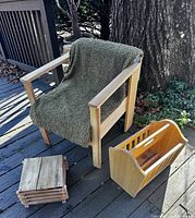 Pine armchair, wood stool, maple magazine rack grouped outdoors