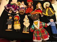 Group shot of all 10 ethnic dolls on black background