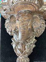 Front view of carved wooden elephant head sconce showing overall design