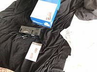 Adapter with box and manual on black fabric