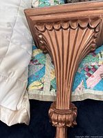 Front view of cast gilded bronze wall sconce shelf showing fluted design and scalloped top edge