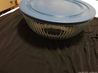 Large fluted clear glass bowl with blue lid