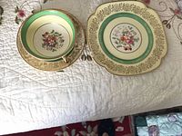 Bowl on saucer beside square sandwich plate, showing pattern and colour
