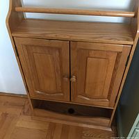 Front view showing doors, towel bar, lower shelf