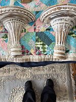 pair of carved wooden whitewashed wall sconces on quilt