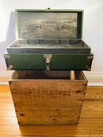 Wood crate and green box, lid open showing tray