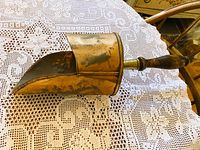 Side view of copper scoop showing riveted body and handle connection