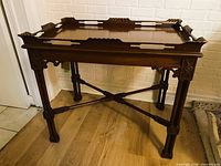 Full view of carved mahogany side table with tray top in place