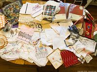Table view of assorted embroidered and crocheted linens, boxed napkins and hankies