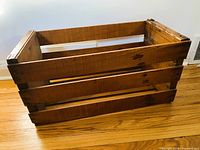 Overall view of rectangular wooden crate showing slatted sides and open top