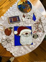 All ten stained glass items displayed on lace tablecloth