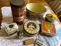 Group shot of all eleven tins on tablecloth