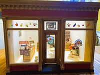 front view of wooden general-store dollhouse with interior contents visible