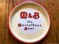 Top view of round tin tray showing logo and rim