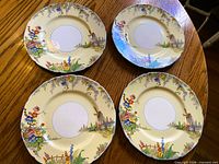 Four Grindley The Old Mill dinner plates displayed on wooden table