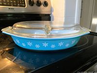Side view showing turquoise dish, snowflake pattern, clear lid