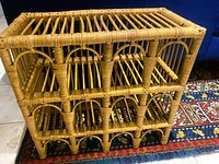 Front angled view of bamboo wine rack showing two tiers and arched bottle slots