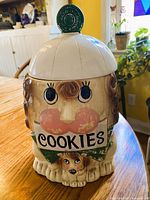 Front view of ceramic lion cookie jar with lid showing “COOKIES” sign