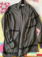 Full view of grey cardigan laid flat showing overall design and condition