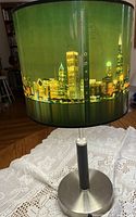 Lamp full view on table lit, showing skyline shade and chrome base