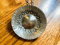 Front view of pewter pendant showing starburst design