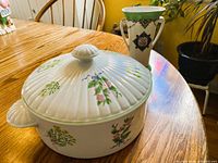 Shafford covered casserole with lid beside Noritake vase on table