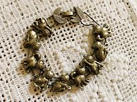 Bracelet laid in circle showing all ten cat charms and clasp