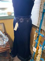 Full length side view of black strapless gown on mannequin with belt