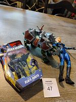 Overview of all three items: boxed Black Manta, Samurai Battle Cat, Invisible Woman figure