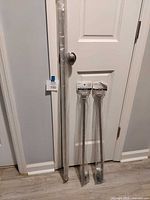 All three curtain rods leaning against door