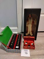 All three boxed items together: doll, calligraphy plaques, Baoding balls