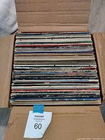 Open cardboard box filled with stacked 12-inch vinyl LP records