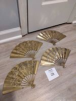 Set of four brass fan plaques laid out