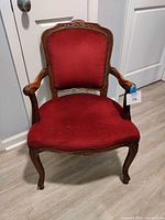 Front view of burgundy Louis XV carved armchair