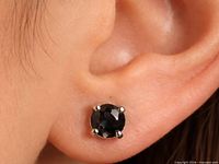Black diamond stud shown worn in ear