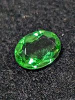 Top view of oval faceted green gemstone