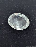 Front view of oval faceted aquamarine gemstone on dark background