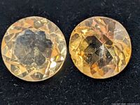 Close-up of two round faceted citrine gemstones
