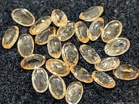 Group of oval faceted citrine gemstones on black background