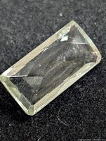 Rectangular pale green gemstone front view showing facets