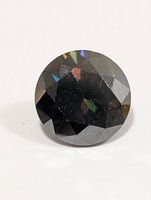 Round faceted moissanite gemstone on white background