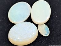 Four opal cabochons displayed on black background