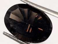 Close-up of oval faceted smoky quartz showing facets and colour