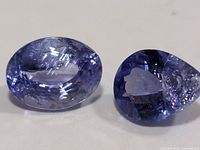 Two loose tanzanite gemstones close-up showing color and damage